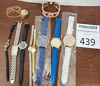 All nine timepieces laid out with MaxSold lot tag visible