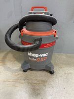 Front view of Shop-Vac QSP vacuum showing hose, casters and graphics