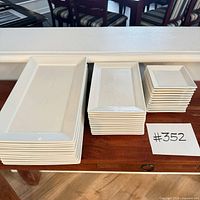 Stacked view of large, medium and small white porcelain plates on table