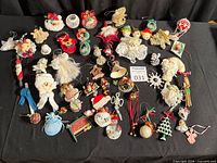 Full group of assorted handmade Christmas ornaments laid out on black cloth