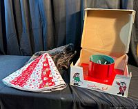 Overview of two tree skirts and tree stand in box