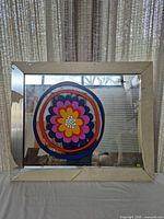 Front view of framed mirror showing floral graphic and frame condition