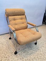 Front left view of lounge chair showing upholstery, frame and casters