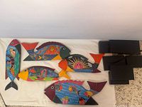 All five wooden fish sculptures displayed on cloth