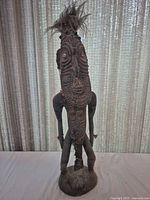Full view of standing carved figure showing overall form and height