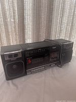 Front view of Sony CFS-1000 boombox showing speakers, cassette deck, equalizer and attached power cord