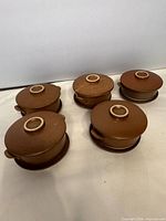 Five covered soup bowls on saucers