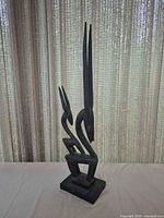 Full view of the carved wood sculpture standing on base