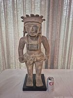 Front view of full sculpture beside soda can for scale