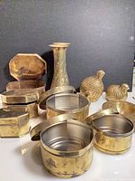 Group view of brass vases, octagonal boxes, round container and quail figurines
