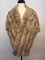 Front view of beige mink fur stole displayed on mannequin