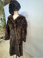 Full view of fur coat on mannequin with hat