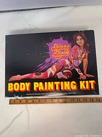 Lid of Skinny Dipper Body Painting Kit showing artwork and title