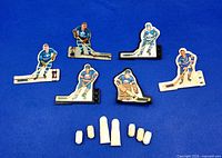 Group shot of all six player figures and nine white replacement parts