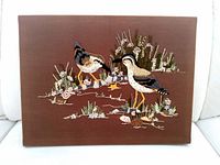 Front view of completed embroidered wall art on brown fabric