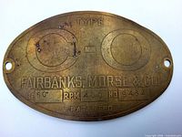 Front of oval brass nameplate showing embossed text and mounting holes