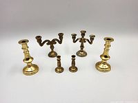 Group shot showing all six brass miniature candleholders