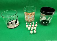 All three tumblers and nine miniature pins grouped on green background