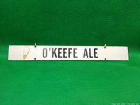 Front view of entire O'Keefe Ale sign showing graphics, clips and condition