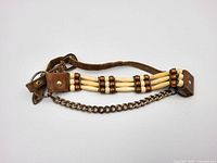 Full view of necklace showing bone beads, leather ends and chain