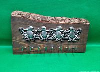 front view of key rack showing four pewter frogs and eight hooks
