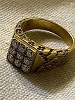 Ring left side view showing square stone cluster and textured shoulders