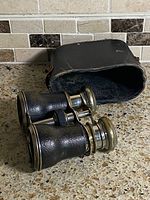 Opera glasses resting beside open leather case