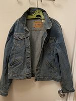 Front view of Levi’s Signature light blue denim trucker jacket on hanger
