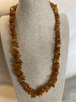Amber chip bead necklace displayed on bust form