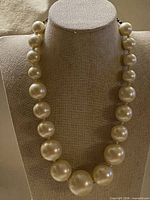 Full view of faux pearl necklace on display bust