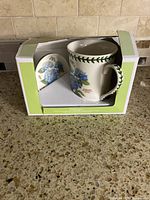 Boxed set showing mug and coaster inside packaging