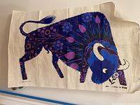 Full view of linen tea towel showing bull design and overall condition