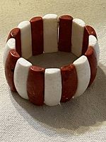 Full view of bracelet standing upright showing alternating red and white coral pieces