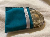 Compact partly inside teal pouch showing Towle ribbon label