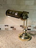 Lamp side view showing brass construction and perforated tubular shade