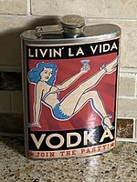 Front view of hip flask showing full pin-up label and cap closed