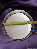 Top view of larger skillet with tape measure showing diameter
