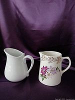 Front view two ceramic milk pitchers, one floral Lord Nelson, one white PC