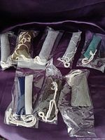 Eight individually bagged fabric catnip toys displayed on purple cloth