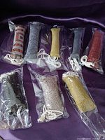 All eight catnip toys in sealed bags on purple fabric