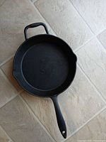 Top view showing interior surface, long handle, helper handle, pour spouts