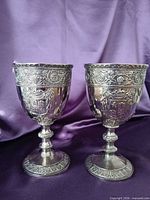 Both ornate silver-plated goblets front view