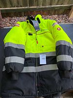 Front view of neon yellow and black insulated coat with tags attached