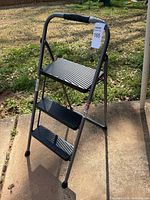 Full view of ladder standing open showing three steps and frame