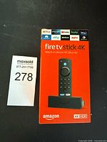 Front of sealed Amazon Fire TV Stick 4K retail box with MaxSold lot tag visible