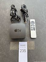 Apple TV unit, cords and remote laid out
