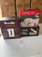 Three boxed kitchen items: Breville kettle, frying pot, Mueller chopper