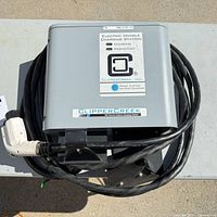 Front view of ClipperCreek wall-mount EV charger with coiled cable and J1772 connector
