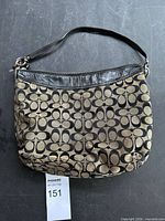 Front view of Coach khaki and black signature C pattern shoulder bag