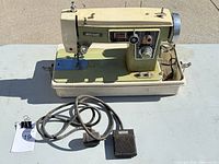 Front and accessories view showing machine, foot pedal, cords and case base